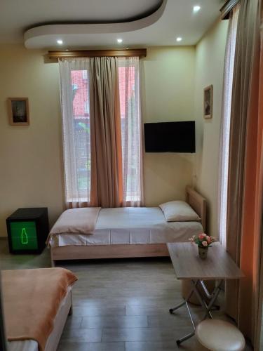 乌雷基MAKA Hotel的一间卧室设有两张床、一台电视和一张桌子