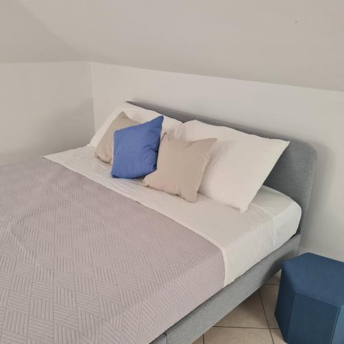 圣焦万尼泰亚蒂诺Gate 25的一张带白色和蓝色枕头的床