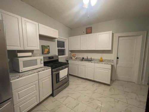 克利夫顿Suite Dream Clifton 27的厨房配有白色橱柜和白色家电
