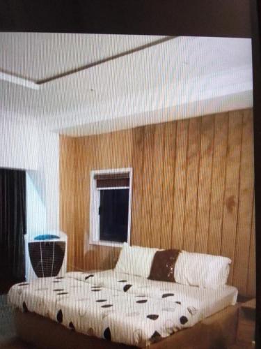 拉各斯N.V HOTEL AND RESORT BEACH view的卧室内的一张床铺,设有木墙