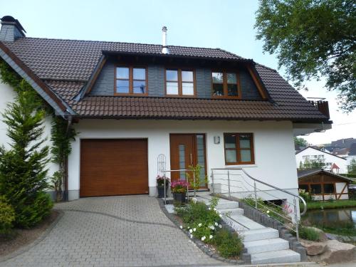 BrachthausenCosy apartment with private garden in Brachthausen in the Sauerland的白色房子,有棕色的屋顶