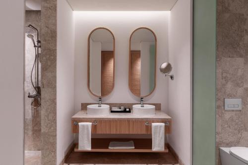 塞拉莱The Club by Fanar的浴室设有2个水槽和2面镜子