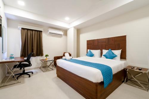 维杰亚瓦达Monday Hotels Swarnas The Capital的配有一张床和一张书桌的酒店客房