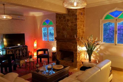 TagadirtVilla de charme, jardin paysagé, piscine privée的带沙发和壁炉的客厅