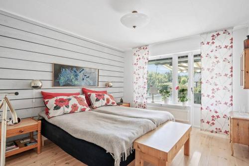 格雷伯斯塔德Hagavägen 5的一间卧室配有一张带红色枕头的大床