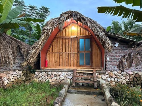 Lai ChâuNhà Tổ Ong的一座带茅草屋顶的小型木制建筑