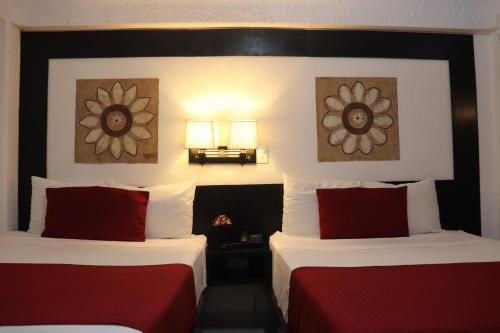 比亚埃尔莫萨巧克酒店的酒店客房 - 带两张带红色枕头的床