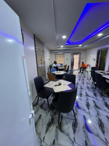 乌约Masters Class Hotels and Apartment的一间配备有桌椅和蓝光的用餐室