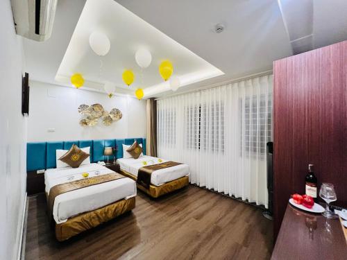 河内Khách Sạn 239的酒店的客房内设有两张床,天花板上设有黄色气球。