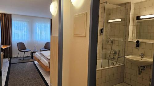 斯图加特Elha Hotel的客房设有带一张床和盥洗盆的浴室