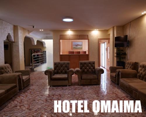 阿尤恩Hotel OMAIMA的酒店客房带沙发和椅子