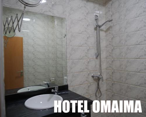 阿尤恩Hotel OMAIMA的带淋浴和水槽的浴室,包括酒店奥玛的词汇