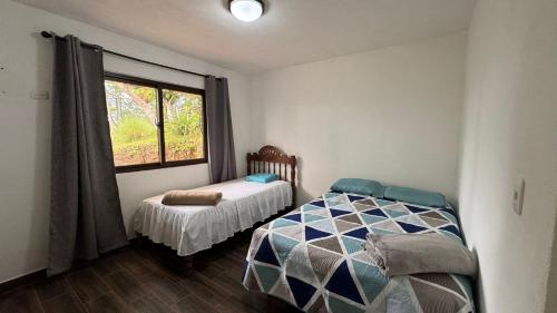 TupulcánCabaña Vista Verde的一间小卧室,配有床和窗户