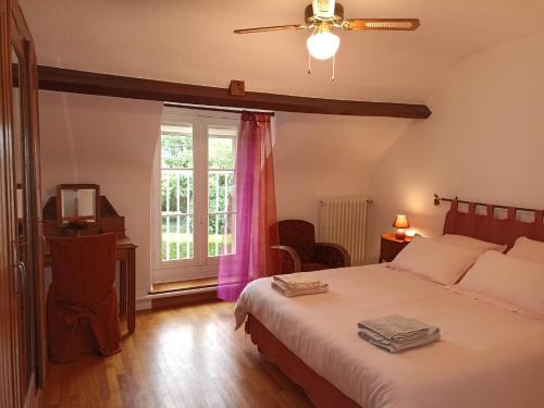 Le Grand VireyLe Nid des Tourterelles的一间卧室设有一张大床和一个窗户。