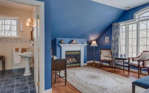CowansvilleManoir Sweetsburg的客厅设有蓝色的墙壁和壁炉。