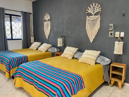 普罗格雷索Itzé Hostel Boutique - Progreso的墙上设有床头板的客房内的两张床