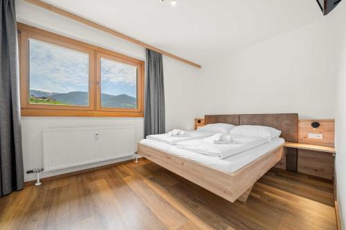 卡普伦Luxus Apartment Kaprun View的一间卧室设有一张床和一个窗口