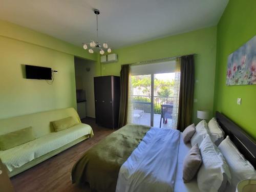 帕尔加Paraskevi's Luxury Studios的绿色卧室配有床和沙发
