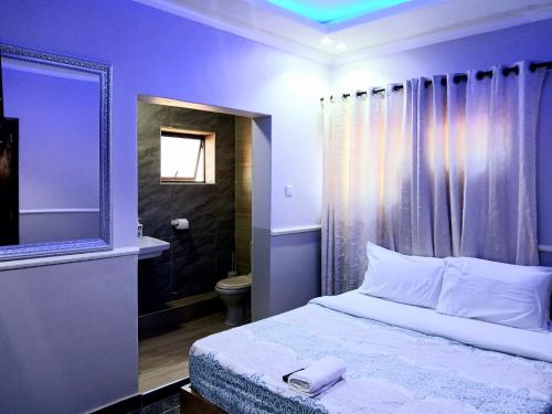 利隆圭FourPoints Lodge的一间卧室配有一张床、一个卫生间和一面镜子