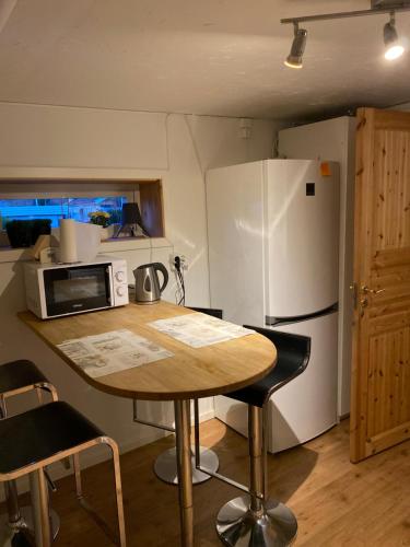 诺尔雪平Lägenhet Skarphagen Norrköping的厨房配有桌子和白色冰箱。