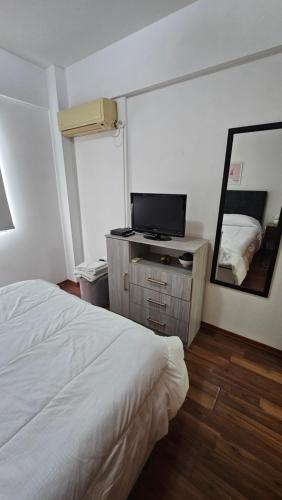 El PalomarAcogedor departamento 1 dormitorio的卧室配有白色的床和镜子