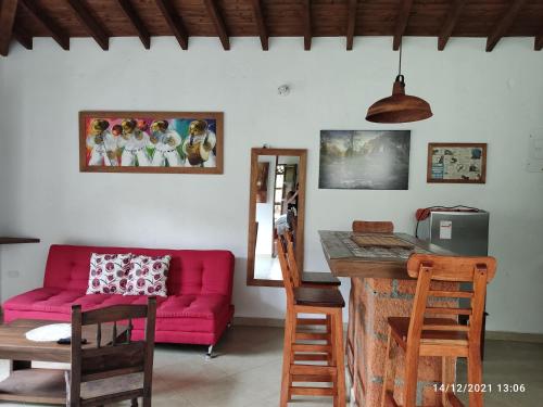 贾丁Casa Hotel Portón Campestre的客厅配有红色的沙发和桌子
