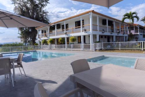 金巴亚Colina del Sol Hotel Hacienda的一座带游泳池和大楼的度假村