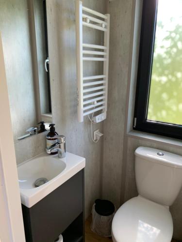 加茨比亚格拉Apartamenty Lido的一间带卫生间、水槽和窗户的浴室