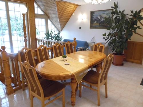 凯斯特海伊Millennium Villa的一间带木桌和椅子的用餐室