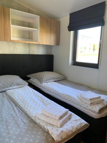 加茨比亚格拉Apartamenty Lido的带窗户的客房内设有两张单人床。