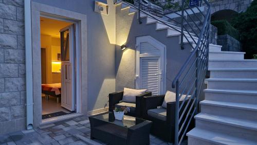 扎通Vitis Apartments的庭院设有椅子、桌子和楼梯。