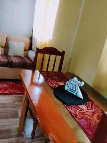 MarigotRiver Splash Apartment & Cottage的小房间,配有桌子和挂着帽子的长凳