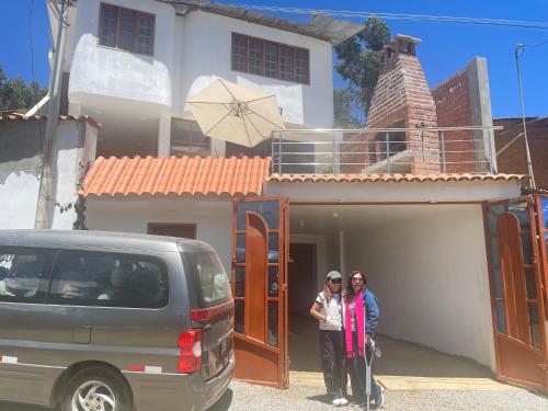 瓦拉斯Casa Hospedaje “YURAQ WASI”的两名妇女站在房子前面