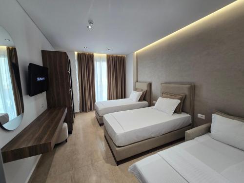 卡萨米尔Sunlight Hotel的酒店客房设有两张床和电视。
