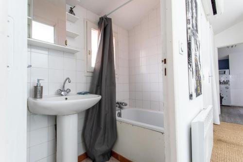 图卢兹T2 Toulouse 40m2, Lit Queen Size, Climatisation, quartier sympa, Terrasse的浴室配有盥洗盆和浴缸。