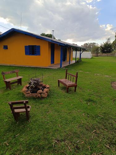 拉热斯Casa Amarela的田野中带长椅和火坑的建筑