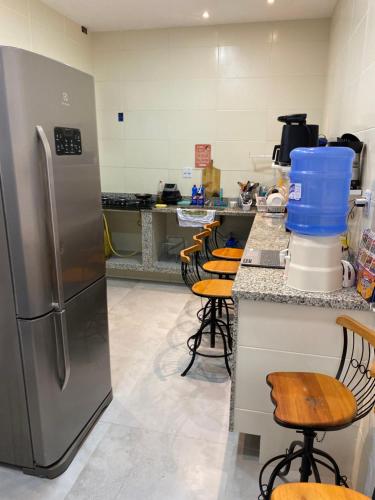 安格拉杜斯雷斯valenshostel的厨房配有不锈钢冰箱和酒吧凳