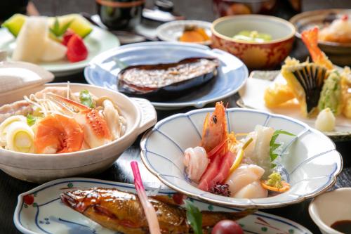佐贺市Tsukasa Ryokan的餐桌,盘子上放着食物和碗