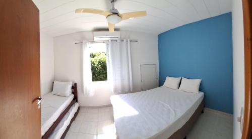 卡拉瓜塔图巴VILLAGIO CHARMOSO NA PRAIA DA MOCOCA的蓝色和白色的卧室设有床和窗户