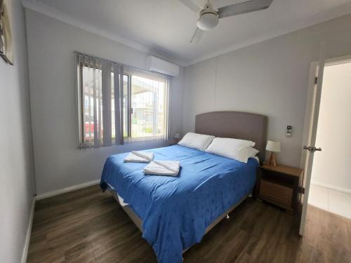 朱里恩湾Unit 26 Seafront Estate的一间卧室设有蓝色的床和窗户。