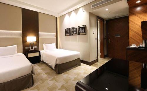 吉达Aerotel Jeddah的酒店客房设有两张床和电视。