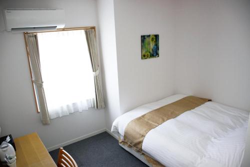 Iidamachiビジネスホテル 山手INN的一间小卧室,配有床和窗户