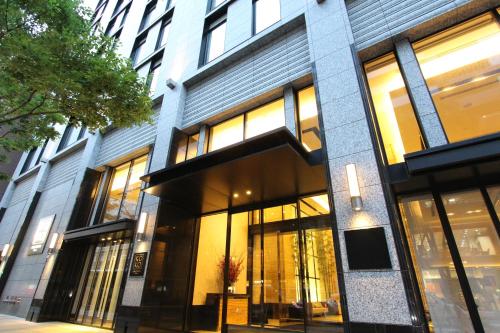 金泽KOKO HOTEL Premier Kanazawa Korinbo的城市街道上一座带大窗户的建筑