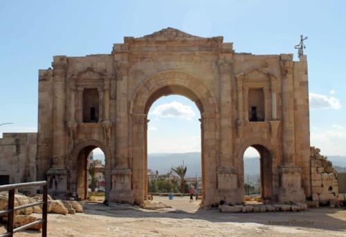 杰拉什Ruins Hotel Jerash的一座古老的建筑,有两个拱门,十字架