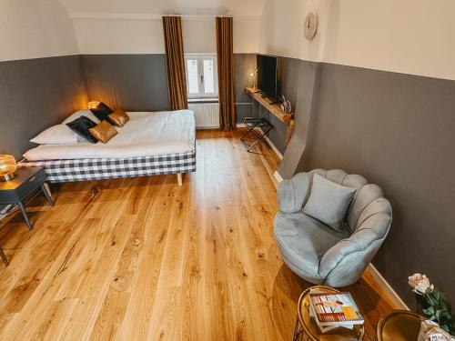 拉纳肯Maas Suites (Maastricht - Lanaken)的小房间设有一张床和一把椅子