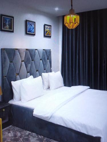 莱基Light house hotel and apartments Lekki phase 1的一间卧室配有一张白色大床和黑色床头板