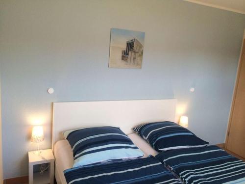 普鲁滕Boddensurfer 3a的一间卧室配有两张蓝色和白色条纹的床