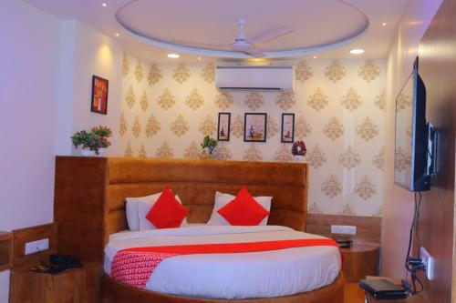 艾哈迈达巴德HOTEL LORDS IN的一间卧室配有一张带红色枕头的大床