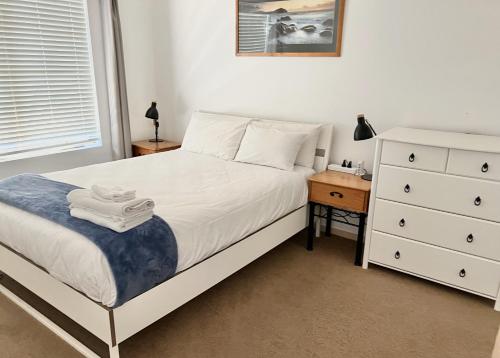 阿德莱德Acgated Parking North Adelaide Balcony Suite的卧室配有白色的床和梳妆台。