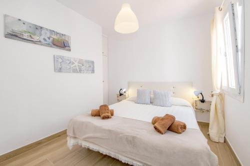 Es GrauFantástico apartamento frente al mar en Menorca的一间白色卧室,配有一张带两个泰迪熊的床